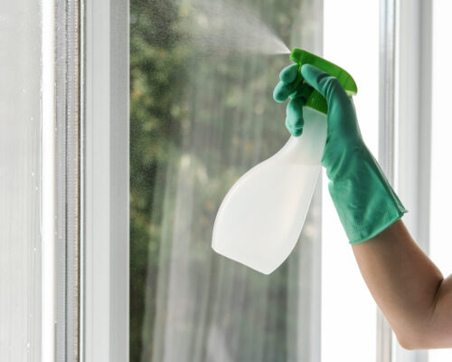 A young woman cleaning window at home. General cleaning concept A young woman cleaning window at home. General cleaning concept